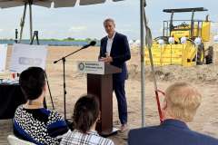 a gentleman in a dark suit speaks at the lectern during the ground breaking ceremony for Rye Ranch Elementary School in Parrish Florida
