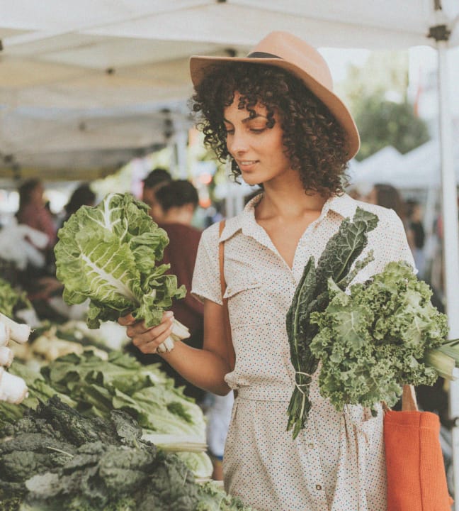 A lady shopping for vegetables at the farmers market