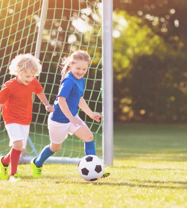 Kids playing soccer on a field at Rye Ranch