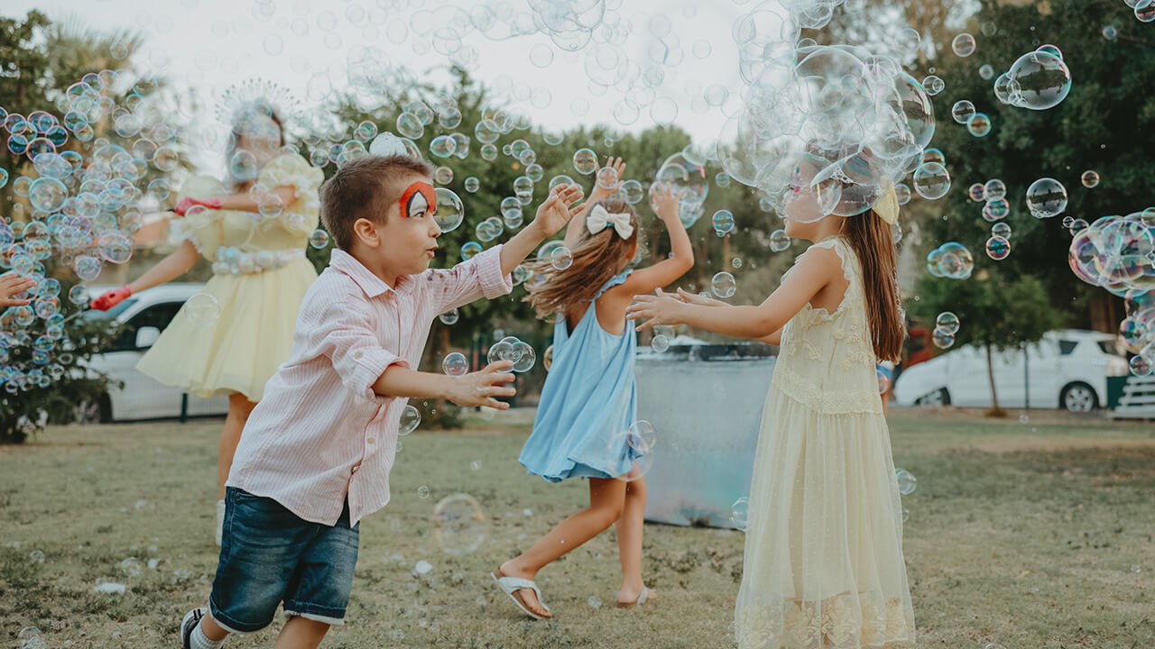 children playing outdoors alongside a bubble-making machine - one of many kinds of events and activations for residents enjoying a lifestyle at Rye Ranch in Parrish Florida