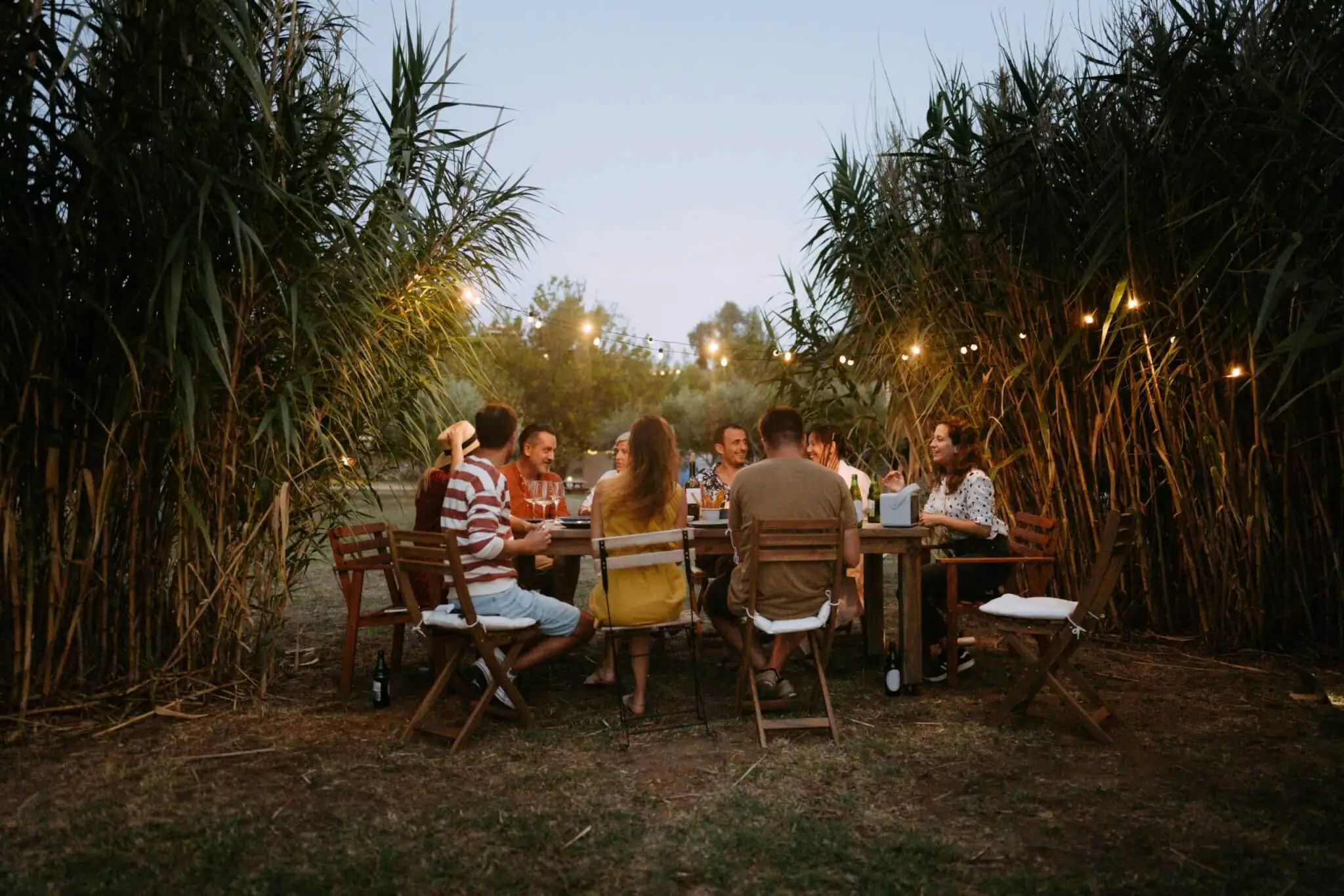 Photo of a small group of friends enjoying the summer dinner party outdoors.