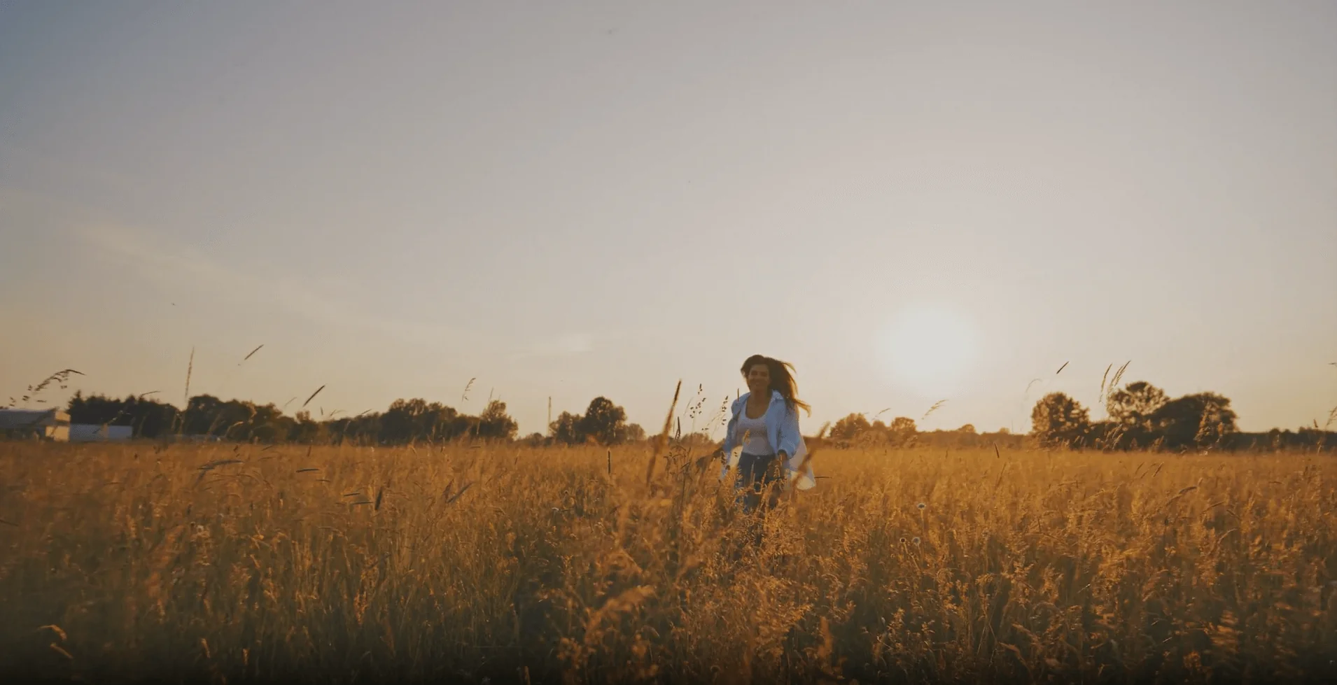 woman running through golden grass