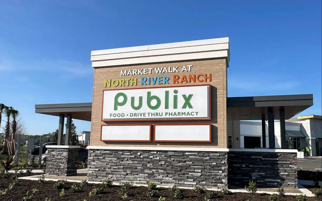 sunny day view of a monument sign featuring the logos of Publix and MarketWalk at North River Ranch - a hidden gem in Parrish Florida